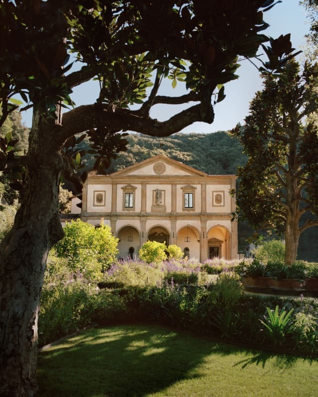 The Michangelo-designed facade stands with palest pink walls amid a sea of green as lush hills climb up behind the gardens